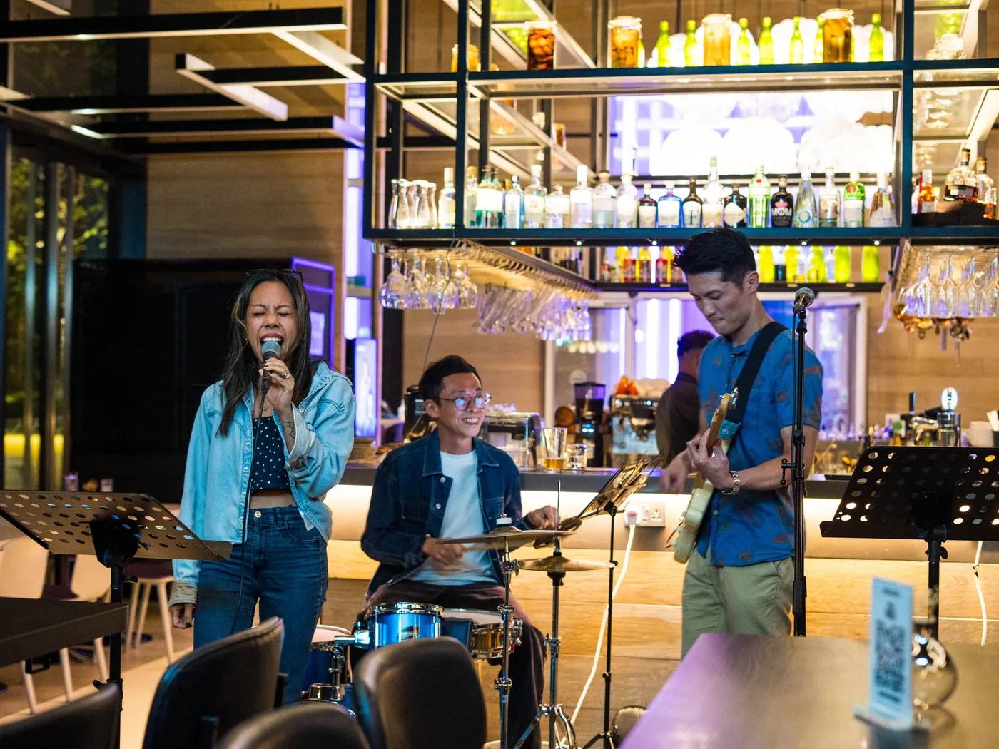 The trio at Komyuniti: NyaLi singing, the drummer grinning, Ze on guitar